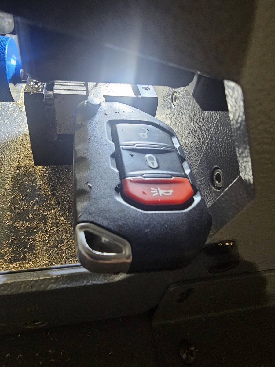 A machine cutting a new key fob for a car.
