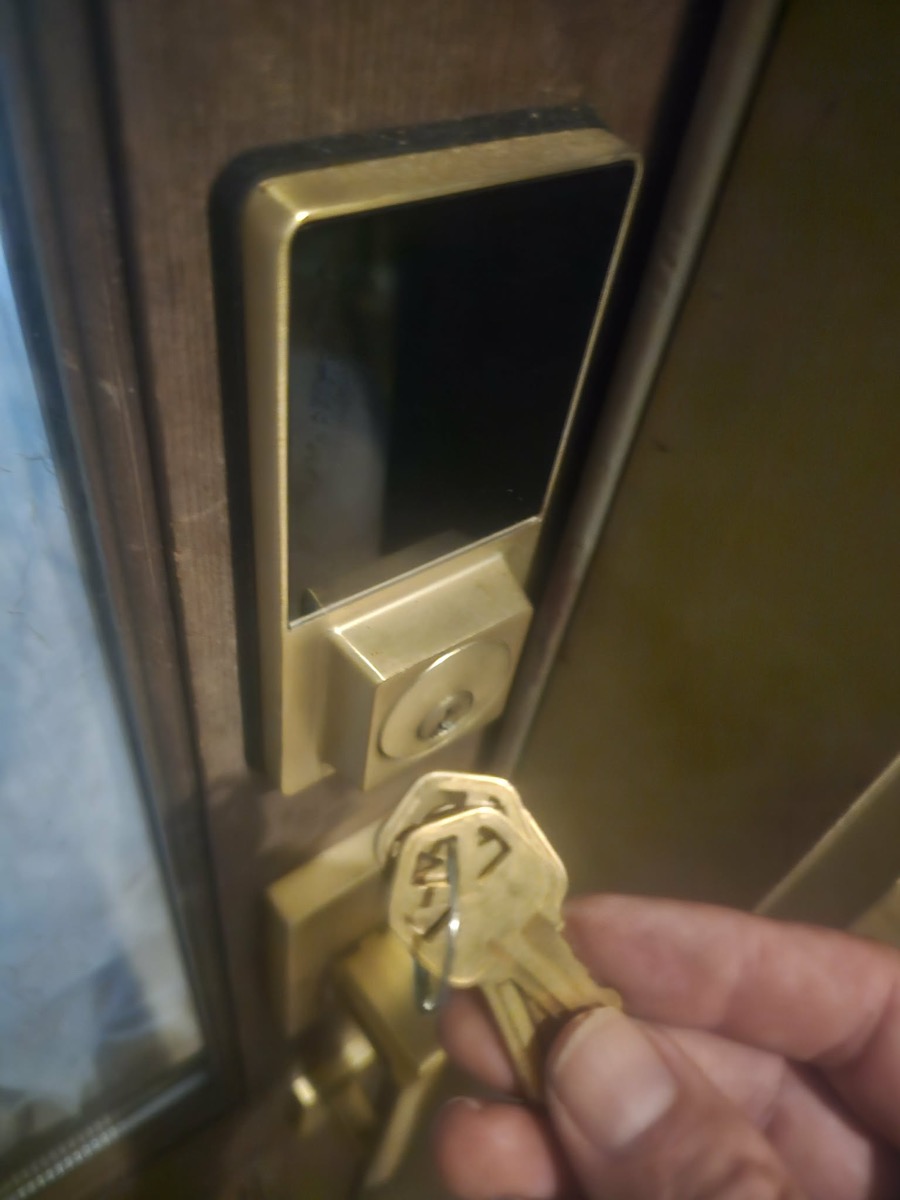 Replacement keys held in front of a newly installed smart lock.